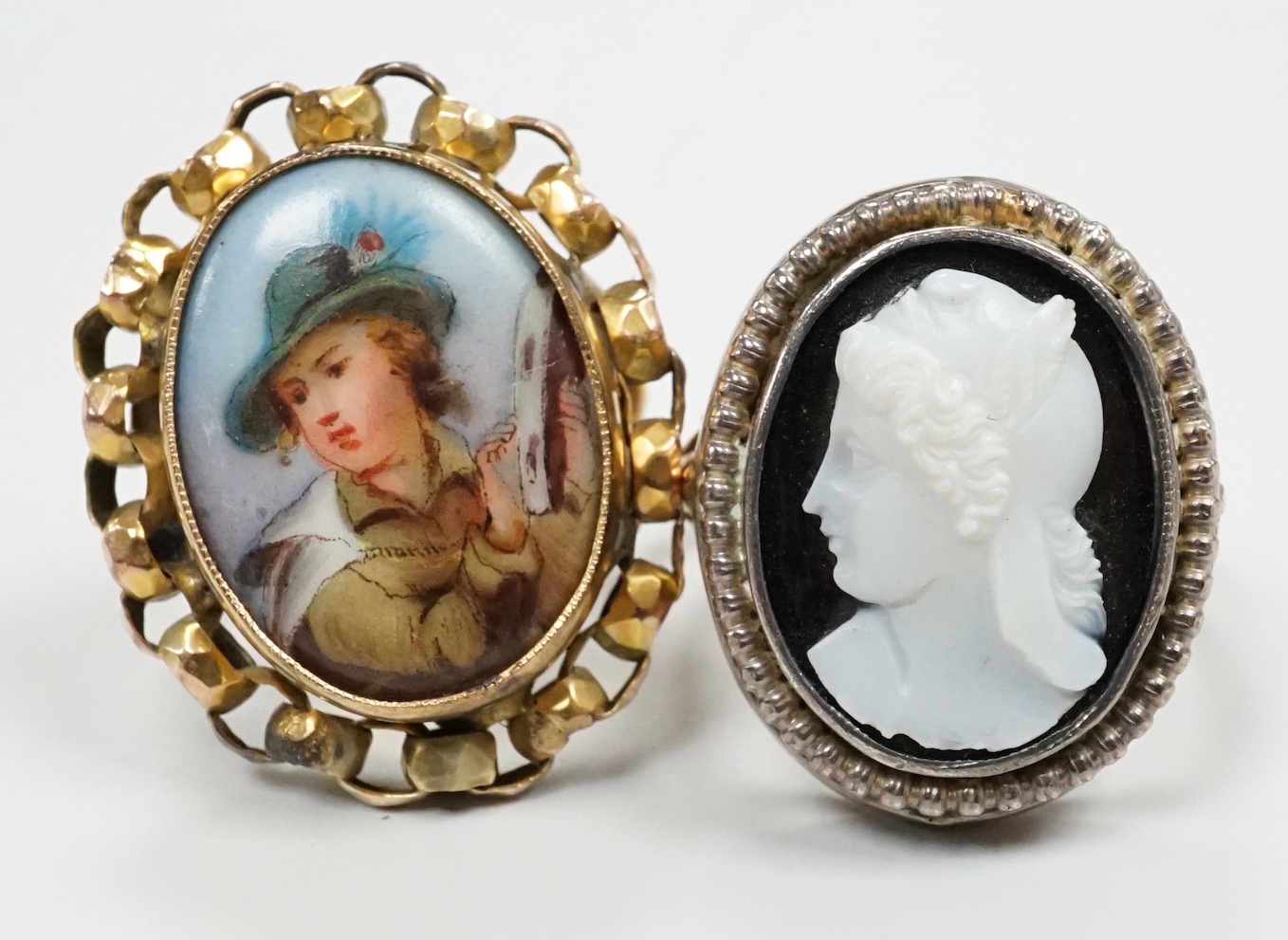 Two yellow metal dress rings, one set with cameo portrait of a lady, the other with porcelain plaque.